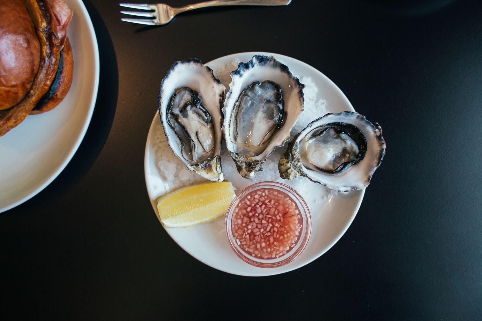 Platter of char-grilled oysters with lemon and grilled bread